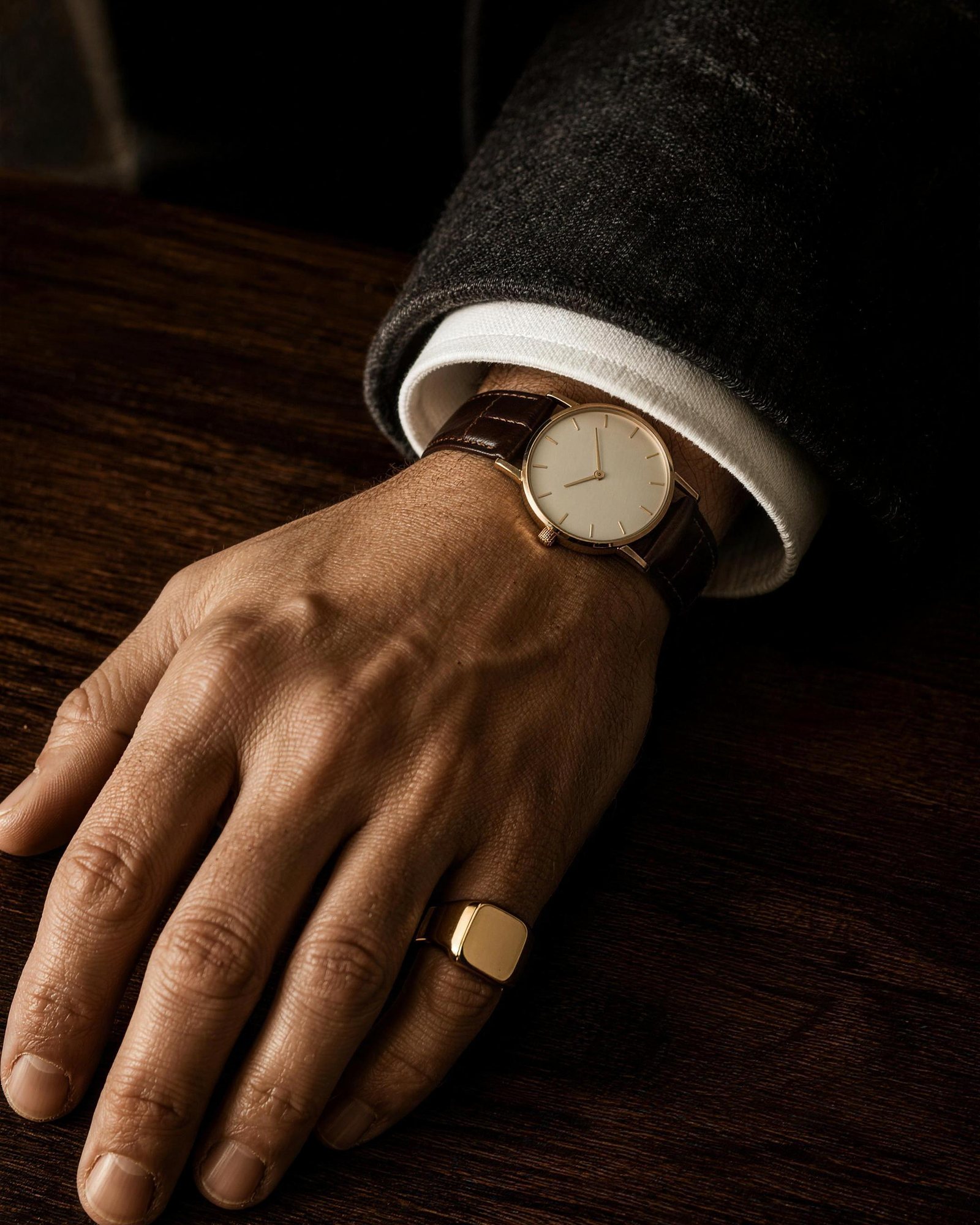 Gold watch and signet ring worn on a man’s hand